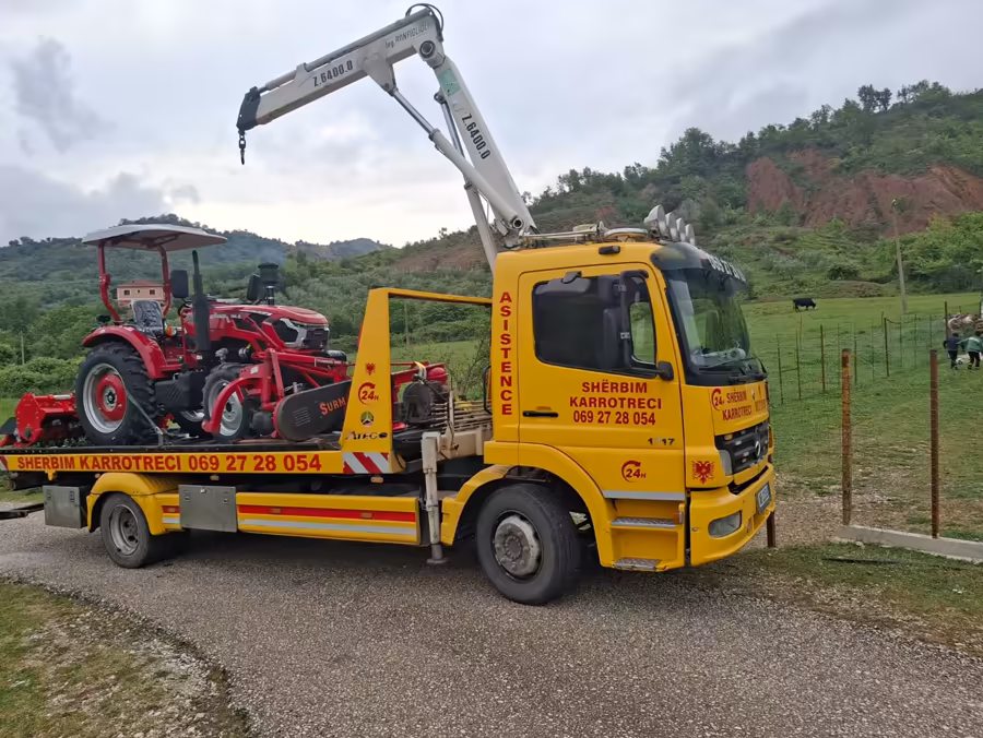 Close-up of a tractor secured on a flatbed tow truck